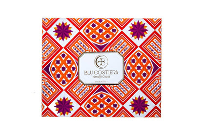 Blu Costiera Amalfi Sunset gift box closed, printed with an orange, red and magenta geometric Amalfi tile pattern with purple starbursts