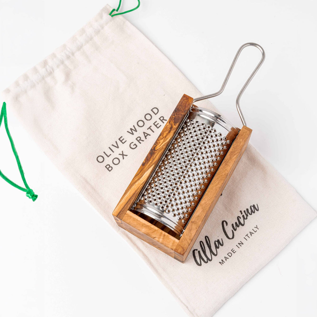 Italian olivewood box cheese grater with its stainless grater plate, shown with the cotton drawstring gift bag printed Alla Cucina, Made in Italy