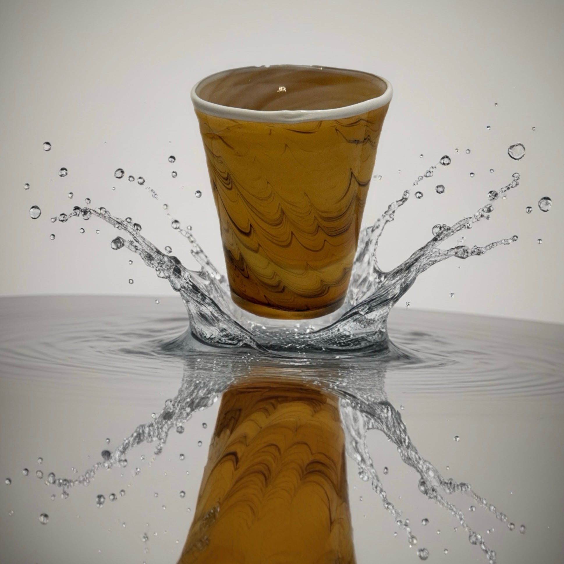 Hand-blown Italian amber glass tumbler with marbled swirl pattern and organic shape