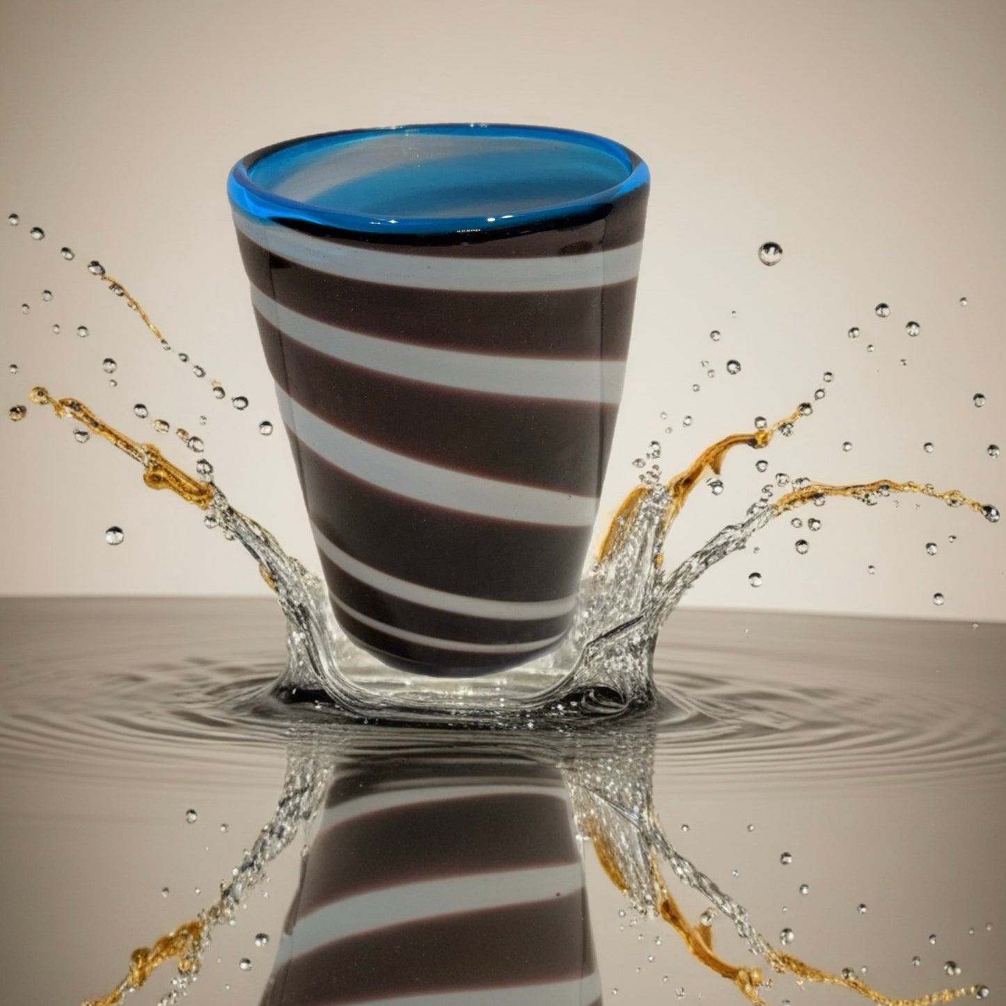 Hand-blown Italian glass tumbler with brown and white spiral pattern and blue rim
