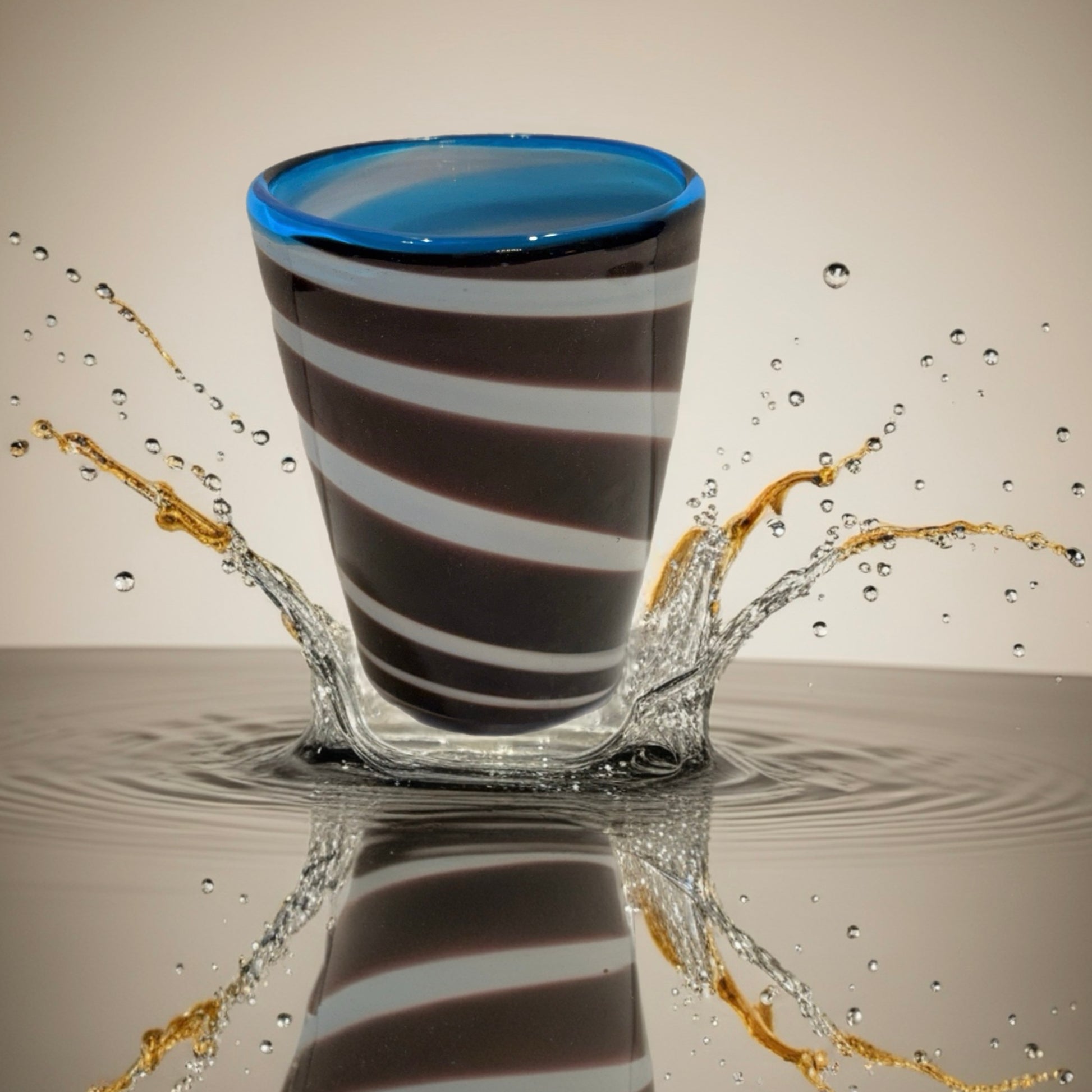 Hand-blown Italian glass tumbler with brown and white spiral pattern and blue rim